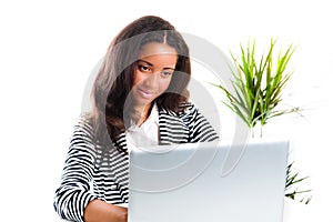 Beautiful mixed race teen girl working on a laptop