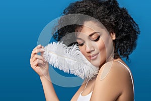 Beautiful mixed race woman holding white ostrich feather