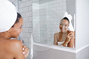 Beautiful mixed race woman looking at her reflection in mirror