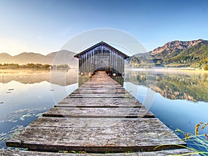 Beautiful mmorning at lake with traditional wooden boat house.