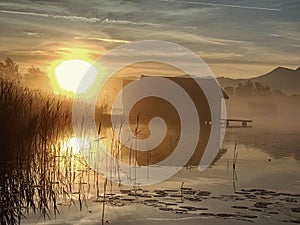 Beautiful mmorning at lake with traditional wooden boat house.