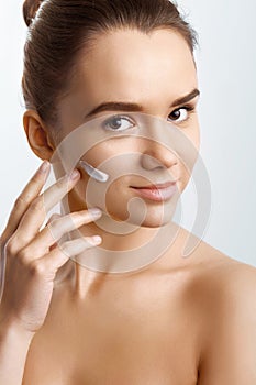 Beautiful model applying cosmetic cream on her face.Beauty Skin Care.