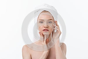 Beautiful model applying cosmetic cream treatment on her face on white.
