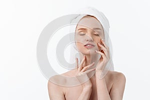 Beautiful model applying cosmetic cream treatment on her face on white.
