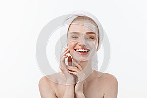 Beautiful model applying cosmetic cream treatment on her face on white.