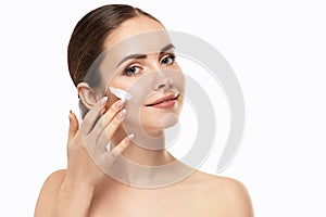 Beautiful Model Applying Cosmetic Cream Treatment On Her Face On White Background.
