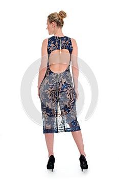 beautiful model with blond hair show printed blue dress for catalog standing back isolated on white