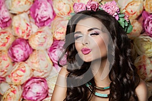 Beautiful Model Blowing a Kiss on Summer Flowers Backgr