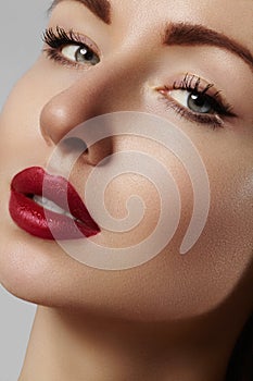 Beautiful model with fashion make-up. Close-up portrait woman with glamour lip gloss makeup and bright eye shadows.