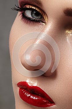 Beautiful model with fashion make-up. Close-up portrait woman with glamour lip gloss makeup and bright eye shadows.