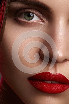 Beautiful model with fashion make-up. Close-up portrait woman with glamour lip gloss makeup and bright eye shadows.
