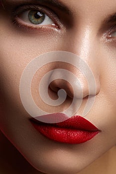 Beautiful model with fashion make-up. Close-up portrait woman with glamour lip gloss makeup and bright eye shadows.