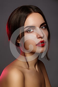 Beautiful model with fashion make-up. Close-up portrait woman with glamour lip gloss makeup and bright eye shadows.