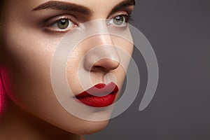 Beautiful model with fashion make-up. Close-up portrait woman with glamour lip gloss makeup and bright eye shadows.