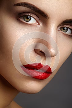 Beautiful model with fashion make-up. Close-up portrait woman with glamour lip gloss makeup and bright eye shadows.