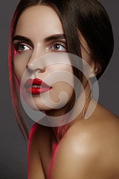 Beautiful model with fashion make-up. Close-up portrait woman with glamour lip gloss makeup and bright eye shadows.