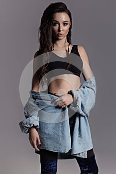 Beautiful model girl in black clothes posing in front of camera in studio