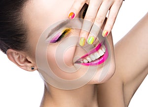 Beautiful model girl with bright colored makeup and nail polish in the summer image. Beauty face. Short colored nails.