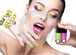 Beautiful model girl with bright colored makeup and nail polish in the summer image. Beauty face. Short colored nails.