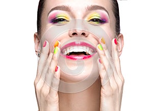 Beautiful model girl with bright colored makeup and nail polish in the summer image. Beauty face. Short colored nails.