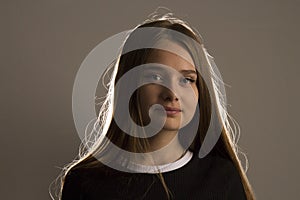 A beautiful model girl with long blonde hair poses in the studio in the light of flashes, the contour light draws