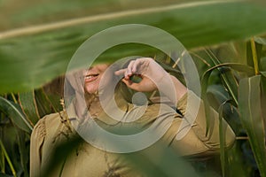 Beautiful model girl with trendy gold makeup posing at camera on morning sunrise over the corn field