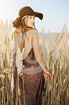 Beautiful model walking in tallgrass at golden hour