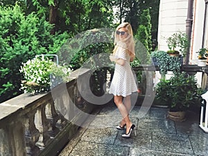 Beautiful model woman wearing polka dots dress in spring garden, luxury fashion and beauty brand