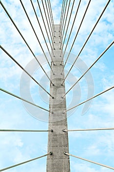 Beautiful modern bridge against blue cloudy sky, low angle view photo