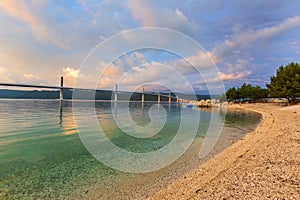 Beautiful modern bridge over the sea on Peljesac in Croatia. In the foreground houses and in the background the Peljesac mountain