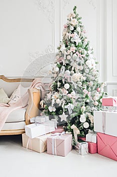 Beautiful modern design of the room in delicate light colors decorated with Christmas tree and decorative elements