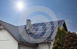 Beautiful modern house with solar panels. Clear sky, sun