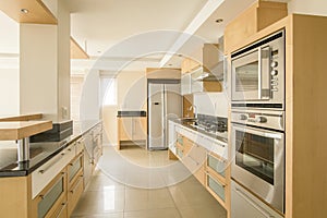 Beautiful modern kitchen with black granite counter tops,large tiled floors and oak doors