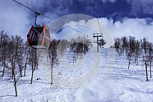 Beautiful modern ski lift cabin and many chair ski lifts at the slope with wild birches, Scandinavian Mountains ski resort