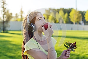 Beautiful modern woman listening to music with her headphones in autumn Sunny Park. Concept of good mood