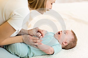 Beautiful mom and her infant baby looking at each other, spending time together at home