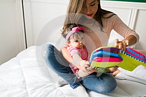 Beautiful mom reading to her baby