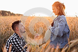 Beautiful moments of pregnancy. Young man gives bouquet of flowers to his pregnant wife. Pregnancy and care. Happiness and