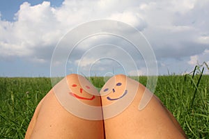 Beautiful moments in two. Peace or love concept. Coceptual blue and red emoticon on girls legs.