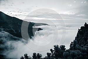 A beautiful monochromatic mountain view with rising clouds