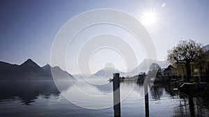 Autumn foliage and fog lake in morning with boat dock