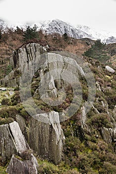 Beautiful moody landscape images of Ogwen Valley in Snowdonia during Winter with snowcapped Glyers mountain range in the