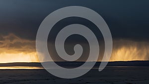 Beautiful moody storm skies over ocean landscape with distant heavy rainfall photo