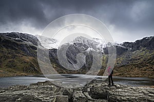 Beautiful moody Winter landscape image of Llyn Idwal and snowcapped Glyders Mountain Range in Snowdonia