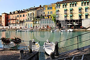 Beautiful morning in Peschiera del Garda town. Colorful houses, architecture view with boats. Little town harbour
