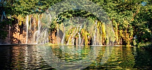Beautiful morning scene of Plitvice National Park. Colorful spring panorama of green forest with pure water lake and waterfall.