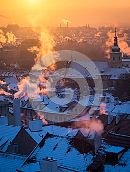 Beautiful morning with sun rising over the Prague roofs covered with fresh snow.