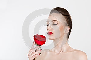 Beautiful moThan smell perfume aroma. Beautiful model woman smelling kissing red rose flower. Sexy red lipsdel woman kissing red
