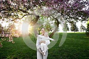 Beautiful Mother And Baby outdoors. Nature. Beauty Mum and her Child playing in Park.