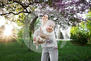 Beautiful Mother And Baby outdoors. Nature. Beauty Mum and her Child playing in Park.